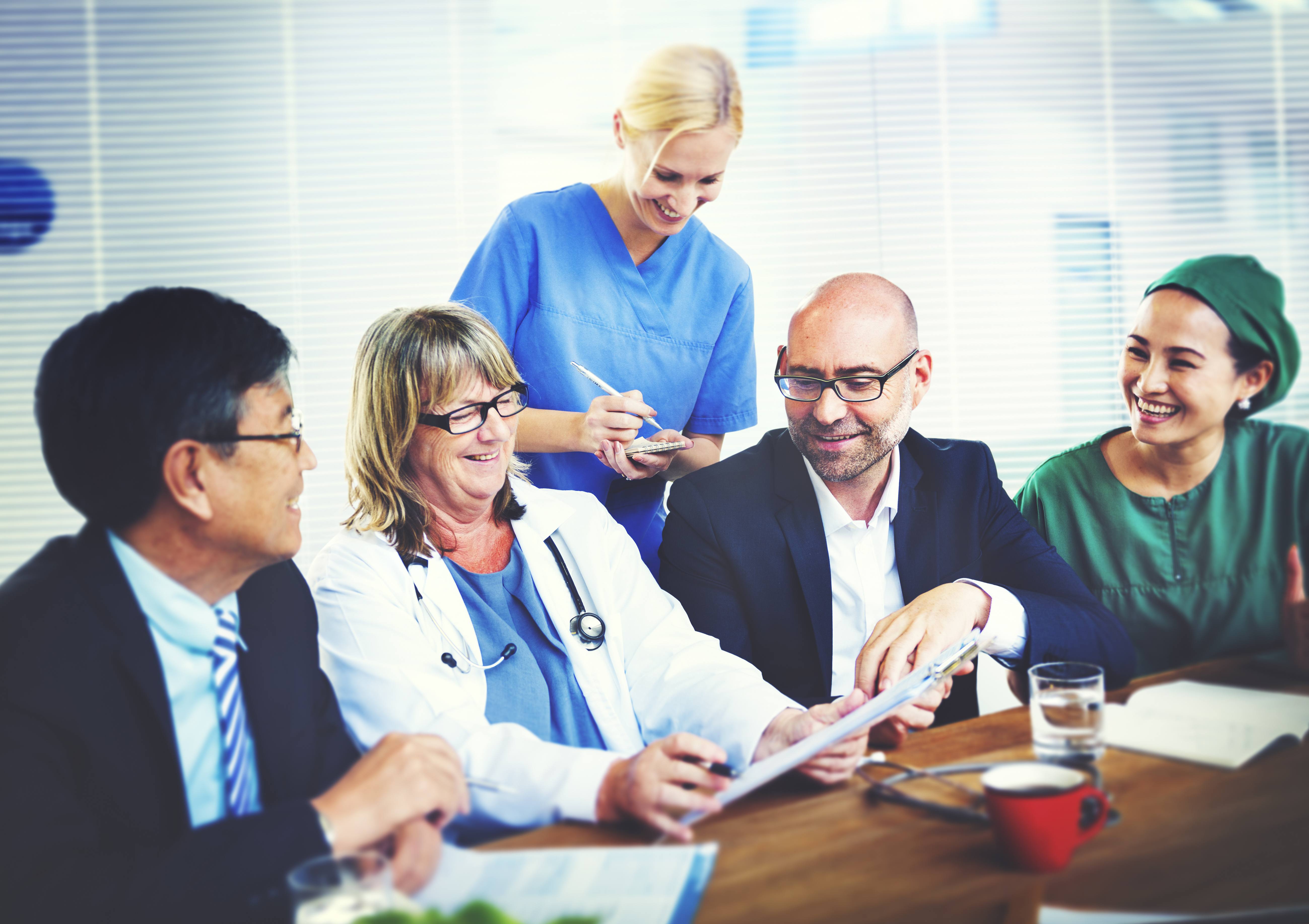 Healthcare professionals smiling together during a staff meeting