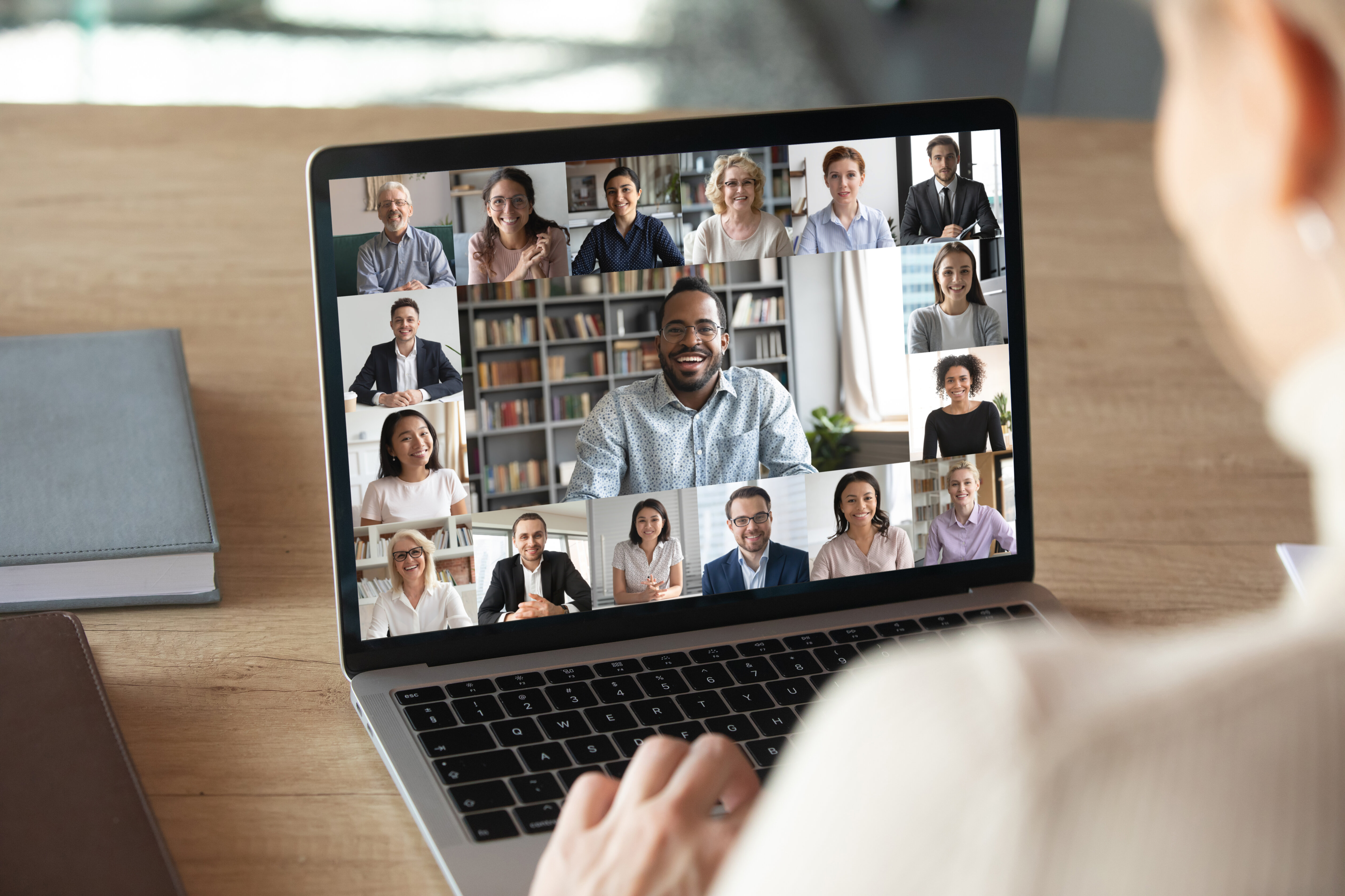 A person on a laptop video call with a grid of healthcare professionals